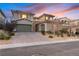 Charming two-story home featuring a neutral color scheme, dual garages, stone accents, and desert landscaping at 193 Elder View Dr, Las Vegas, NV 89138