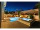 Backyard oasis with pool, spa, and lush landscaping illuminated at night at 193 Elder View Dr, Las Vegas, NV 89138
