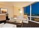 Comfortable sitting area features a sofa, side chair, glass coffee table, and expansive views of the city at 2000 Fashion Show Dr # 5300, Las Vegas, NV 89109