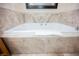 Elegant bathroom showcasing a large soaking tub with marble tile surround and a modern faucet at 2000 N Fashion Show Dr # 4302, Las Vegas, NV 89109