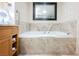 Bathroom featuring a soaking tub with marble surround and tile, creating a luxurious spa-like experience at 2000 N Fashion Show Dr # 4302, Las Vegas, NV 89109