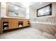 Bright bathroom featuring a large vanity with double sinks and a soaking tub with marble tile surround at 2000 N Fashion Show Dr # 4302, Las Vegas, NV 89109