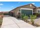 Exterior view featuring a two-car garage, desert landscaping, gate to backyard and hardscaped walkway at 2091 Hunt Woods Ct, Laughlin, NV 89029