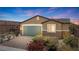 Beautiful single-story home featuring desert landscaping and a two-car garage with decorative stone accents at 2091 Hunt Woods Ct, Laughlin, NV 89029