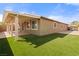 Home's exterior with a covered patio, lush turf, and ample parking visible from the backyard at 2091 Hunt Woods Ct, Laughlin, NV 89029