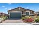 Attractive single-story home features a two-car garage, brick driveway, and colorful garden at 2091 Hunt Woods Ct, Laughlin, NV 89029