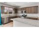 Modern kitchen with a large granite island, stainless appliances, and dark wood cabinets at 2091 Hunt Woods Ct, Laughlin, NV 89029