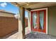 Relax on this covered brick patio with a red framed glass panel door at 2091 Hunt Woods Ct, Laughlin, NV 89029