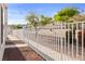 The backyard has a white fence, rock landscaping, mature trees, and bright blue sky at 2146 High Dunes Ln, Laughlin, NV 89029