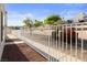 The backyard has a white fence, rock landscaping, mature trees, and bright blue sky at 2146 High Dunes Ln, Laughlin, NV 89029