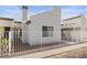 Contemporary home featuring neutral stucco, white fence, desert landscaping and bright sky at 2146 High Dunes Ln, Laughlin, NV 89029
