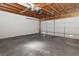 Spacious garage with concrete flooring, exposed wooden beams, and an overhead ceiling fan at 2146 High Dunes Ln, Laughlin, NV 89029