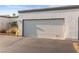 Attached one-car garage with white door and desert landscaping for a home in a Las Vegas neighborhood at 2146 High Dunes Ln, Laughlin, NV 89029