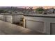 Row of garages at dusk with desert landscaping at this home with mountain views at 2146 High Dunes Ln, Laughlin, NV 89029
