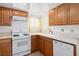 A kitchen showing wood cabinets, white appliances, and light countertops at 2146 High Dunes Ln, Laughlin, NV 89029
