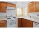 A well-lit kitchen showcasing wood cabinets, white countertops, and a white range oven at 2146 High Dunes Ln, Laughlin, NV 89029