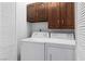 Laundry room with white washer and dryer and overhead wood cabinets at 2146 High Dunes Ln, Laughlin, NV 89029