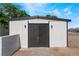 Exterior shot of the garage with black doors and lighting against the white facade at 2716 Saber Dr, North Las Vegas, NV 89032