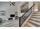Bright living room featuring modern staircase, sleek ceiling fan, and floating display shelves at 2787 Fountain Ridge Ln, Henderson, NV 89074