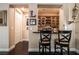 Charming home bar with dark wood floors, cabinets, countertop, and seating for two at 3041 Hammerwood Dr, Las Vegas, NV 89135