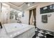 A luxurious bathroom features a large tub with marble surround and elegant fixtures at 3041 Hammerwood Dr, Las Vegas, NV 89135