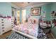 Bright bedroom with colorful rainbow bedspread, complemented with white trim and blue walls at 3041 Hammerwood Dr, Las Vegas, NV 89135