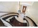 A view from the top of a curved staircase into the foyer and entry door at 3041 Hammerwood Dr, Las Vegas, NV 89135