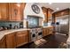 Gourmet kitchen featuring wood cabinets, stainless steel appliances, mosaic backsplash, and spacious countertops at 3041 Hammerwood Dr, Las Vegas, NV 89135