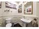 Stylish half bathroom with elegant mirror, lighting, toilet and pedestal sink at 3041 Hammerwood Dr, Las Vegas, NV 89135