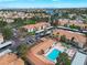 An aerial view of the property with a beautiful community pool in a neighborhood setting with a lake in the background at 3151 Soaring Gulls Dr # 1192, Las Vegas, NV 89128