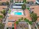 Aerial view of a community pool and hot tub surrounded by landscaping and apartment buildings with red tile roofs at 3151 Soaring Gulls Dr # 1192, Las Vegas, NV 89128