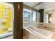 Bright bathroom with a soaking tub, vessel sink, modern fixtures, and beautiful city views at 3722 Las Vegas Blvd # 1908, Las Vegas, NV 89158