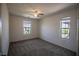 Empty bedroom featuring carpet, ceiling fan, and natural lighting from two windows at 386 Espressivo St, Henderson, NV 89011