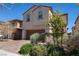 Two-story home with a dark wood garage door, brick driveway and manicured landscaping at 386 Espressivo St, Henderson, NV 89011