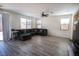 Bright living room with wood tile floors, a ceiling fan, and a gray sectional sofa at 386 Espressivo St, Henderson, NV 89011