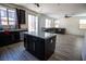 Kitchen island flows to the living room with wood tile floors and a view to the backyard at 386 Espressivo St, Henderson, NV 89011