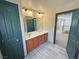 A full bathroom with a wood vanity, bright lighting, mirror, and tile flooring at 3938 E Chaffe Ave, Pahrump, NV 89061