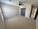 A carpeted bedroom featuring a closet, fan, and a window for natural light at 3938 E Chaffe Ave, Pahrump, NV 89061