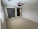 A carpeted bedroom featuring a large closet, fan, and doorway to another room at 3938 E Chaffe Ave, Pahrump, NV 89061