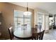 Cozy dining area featuring a round wooden table, pendant lighting, and a view of the backyard at 3961 Equinox Ct, Las Vegas, NV 89147