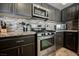 Well-equipped kitchen with stainless steel range, gray cabinets, and stylish backsplash at 3961 Equinox Ct, Las Vegas, NV 89147