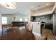 Open-concept space including a kitchen with black cabinets, living area and dining area with view of the backyard at 3961 Equinox Ct, Las Vegas, NV 89147