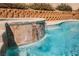 Serene pool waterfall feature with decorative stone, enhancing the backyard's ambiance at 3961 Equinox Ct, Las Vegas, NV 89147
