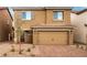 Two-story home with a tan exterior, brown shutters, two-car garage and desert landscaping at 4253 Gold Desert St, North Las Vegas, NV 89032