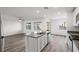 Open concept kitchen with white cabinetry, stainless steel appliances, and adjacent living space at 4253 Gold Desert St, North Las Vegas, NV 89032