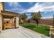 Landscaped backyard showcases a covered patio with bench overlooking a green lawn at 4429 S Glory Vine Ln, Pahrump, NV 89061