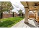 Manicured backyard with green lawn, bench and privacy fence for outdoor enjoyment at 4429 S Glory Vine Ln, Pahrump, NV 89061