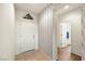 Hallway with wood-look floors, patterned wallpaper, and doors leading to the bathroom and rooms at 4429 S Glory Vine Ln, Pahrump, NV 89061
