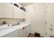 Practical laundry room equipped with a washer, dryer, storage cabinets, and stylish wood-look floors at 4429 S Glory Vine Ln, Pahrump, NV 89061