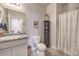 Clean bathroom with tiled floors, granite countertop, and a shower with a white curtain at 4442 Solitude Falls Ave, North Las Vegas, NV 89084